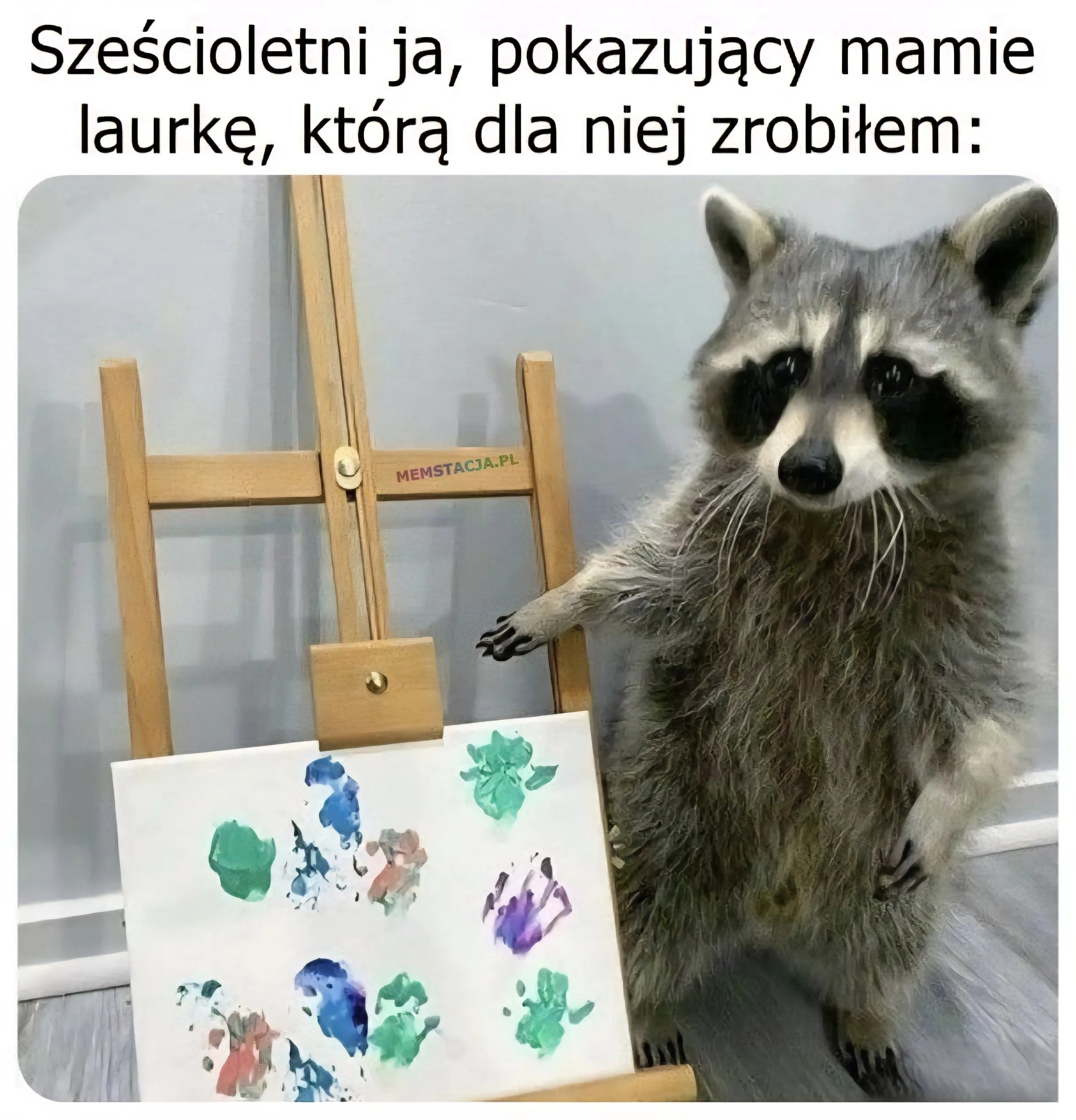 Mem o tytule: Laurka dla mamy 馃榿 Sze艣cioletni ja, pokazuj膮cy mammie laurk臋, kt贸r膮 dla niej zrobi艂em: Zdj臋cie szopa pracza prezentuj膮cego sw贸j obraz.