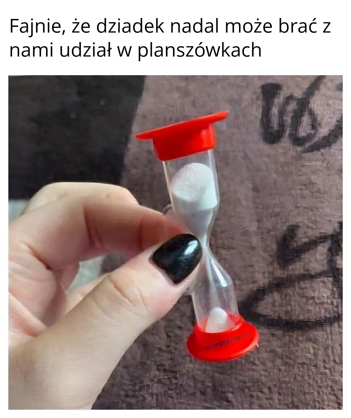 Fajnie, że dziadek nadal może brać z nami udział w planszówkach: Zdjęcie reki kobiety, która trzyma małą klepsydrę.